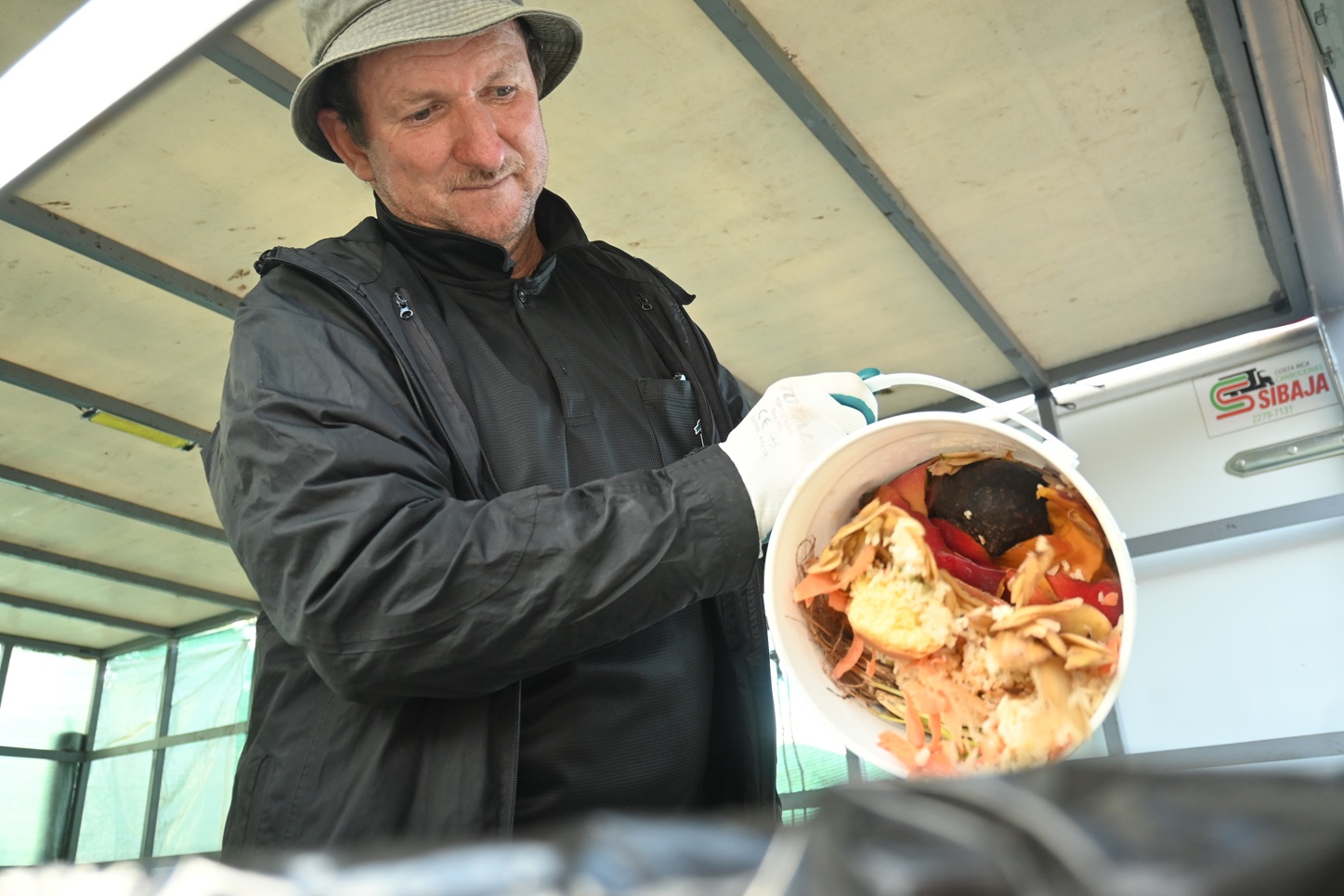 A man with a bucket full of organic waste